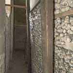 Žehuň - kostnice, ulička mezi stěnou stavby a stěnou z ostatků (2018)