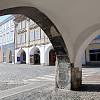 Průhled podloubím na jižní frontu domů na Karlově náměstí